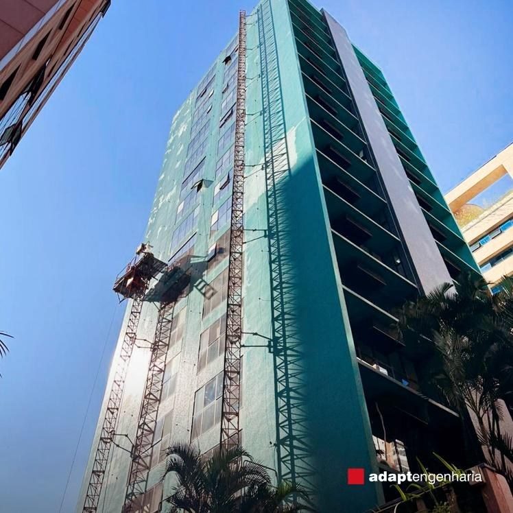 Edifício em obra com tela de proteção durante recuperação de fachada
